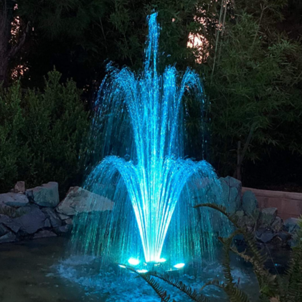 Wiedamark LED Floating Fountain with RGB lights creating a colorful water display in a serene pond at night.